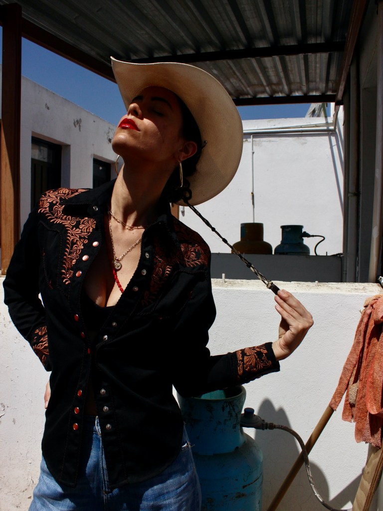 Portrait of Ash(ley) Michelle C. poet artist wearing a cowgirl hat.